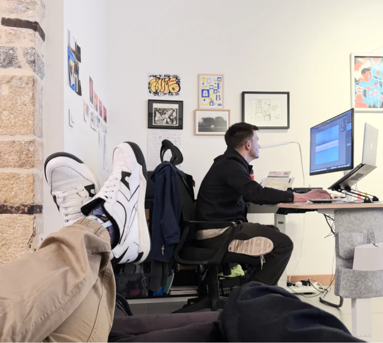 Un coworker à son bureau, entouré d’affiches et de dessins